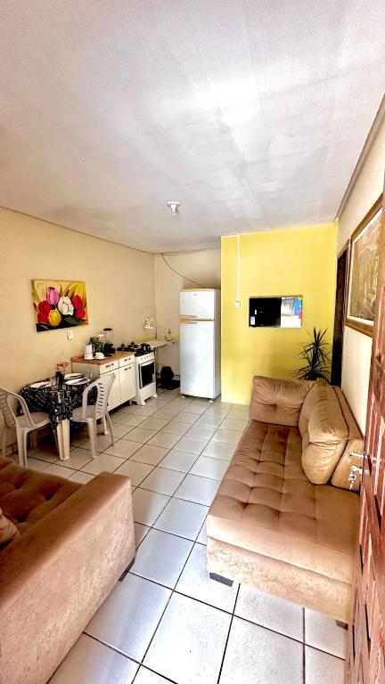 ein Wohnzimmer mit Couch und Küche in der Unterkunft Suíte privativa com cozinha completa, ar e Wi-Fi in Palmas