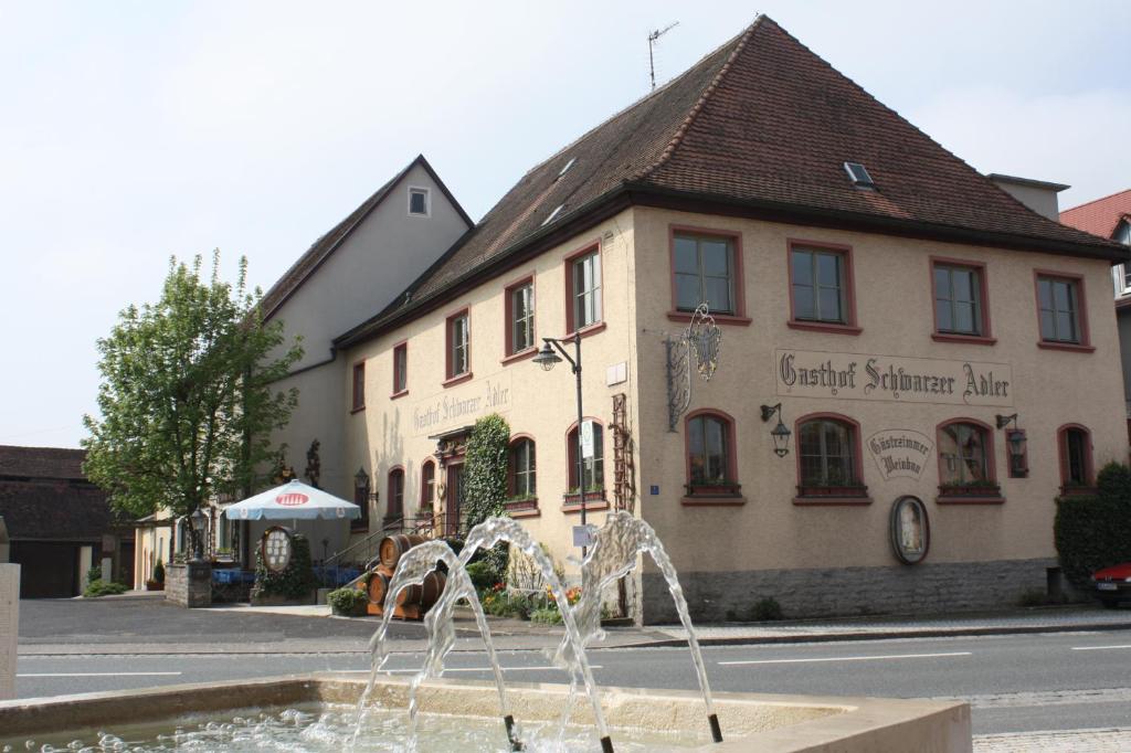 a water fountain in front of a building at Schwarzer Adler - Hotel Garni in Ipsheim