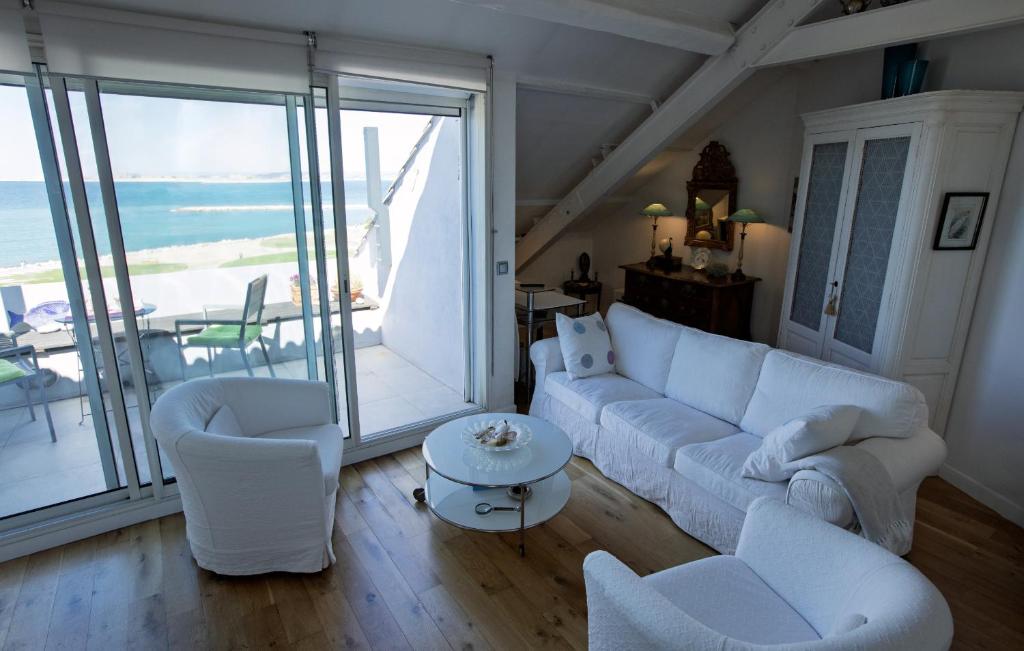 d'un salon avec un mobilier blanc et une vue sur l'océan. dans l'établissement Les Palmiers, à Marseille