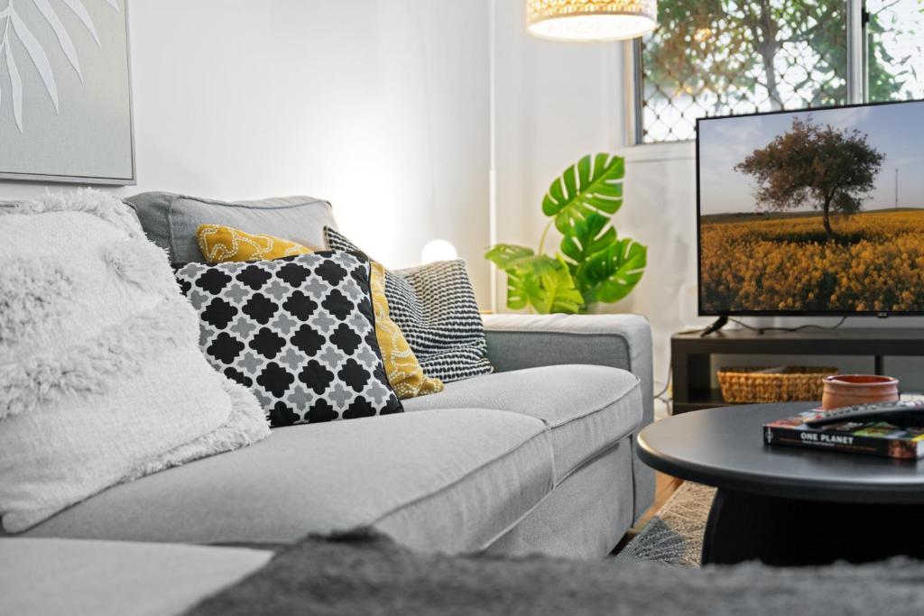 a living room with a couch and a tv at Spacious 3-Bed House in Leafy Paddington in Brisbane