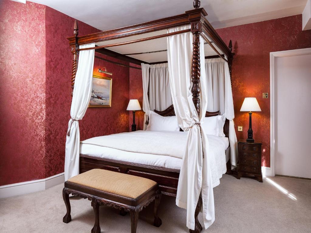 a hotel room with a large bed and a large window at The Angel Posting House & Livery in Guildford