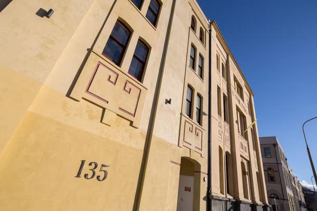 a building with a clock on the side of it at Cumberland Street deluxe apartment No1 in Dunedin