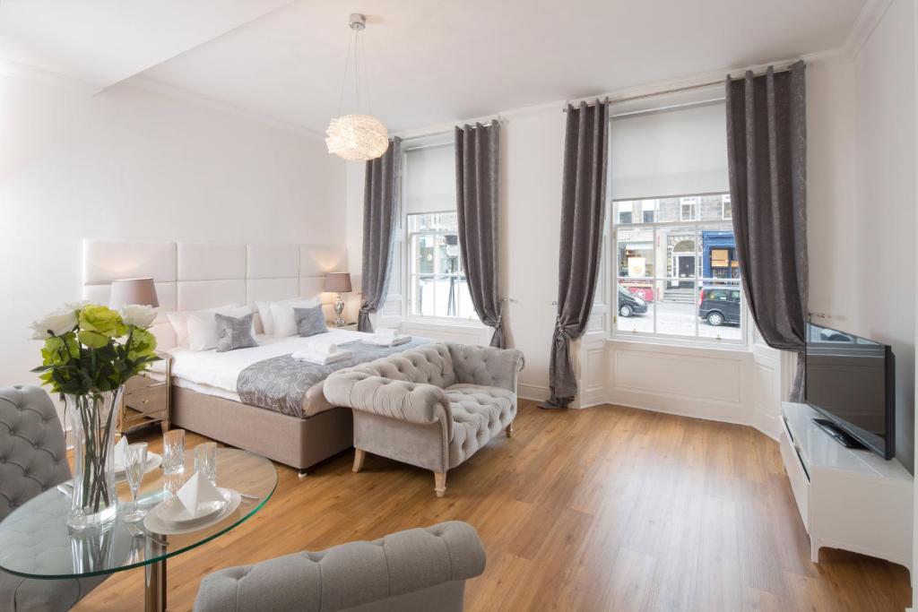 a living room with a bed and a couch and a table at Edinburgh Castle Apartments in Edinburgh