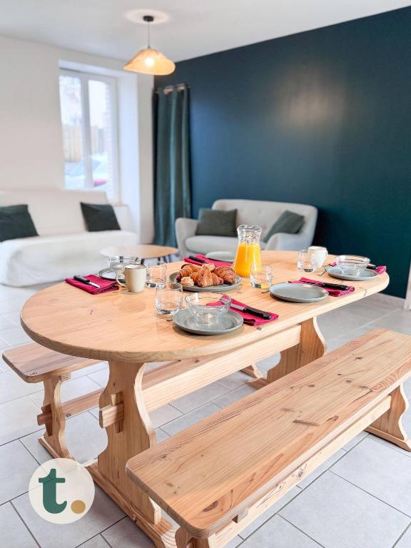 - une table en bois avec de la nourriture dans le salon dans l'établissement Tranquiloue - Maison Familiale - 15min Puy du Fou, aux Herbiers
