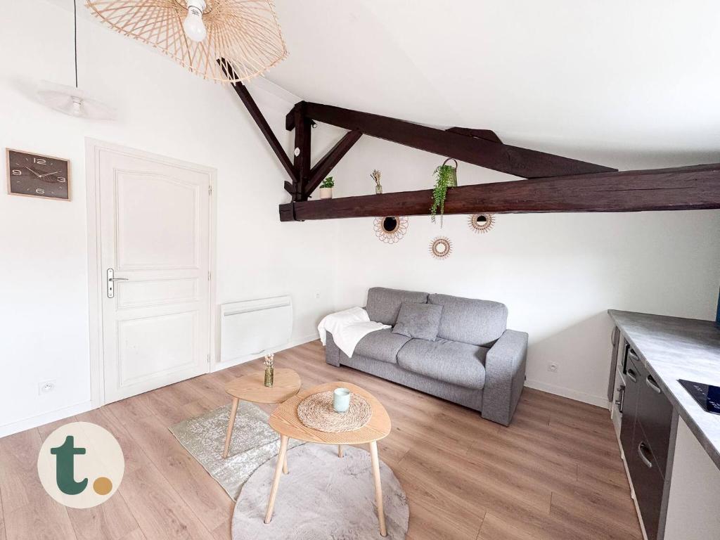 un salon avec un canapé et une table dans l'établissement Tranquiloue - Petit Appartement - 10min Puy du Fou, aux Herbiers