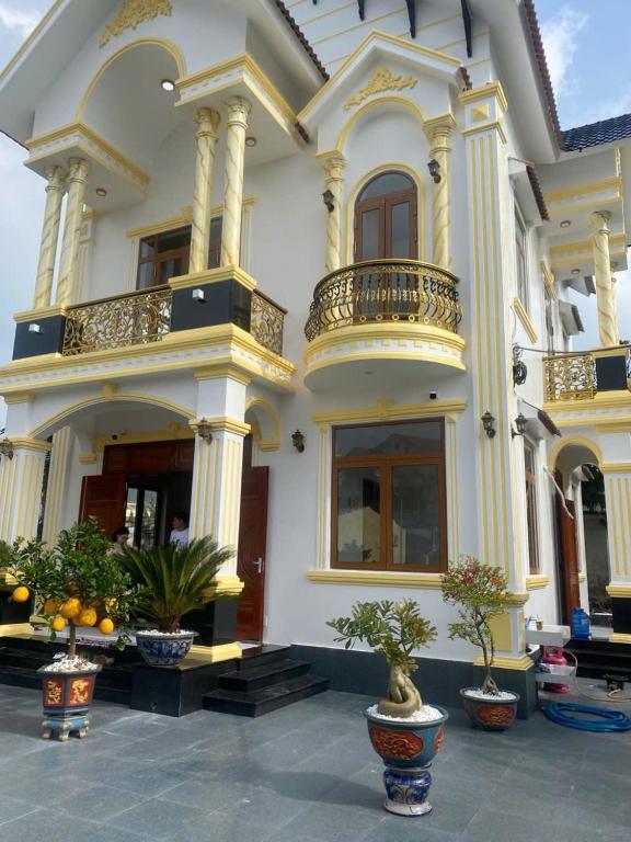 a large white building with potted plants in front of it at Biệt Thự Villa Thảo Vy in Ly Son
