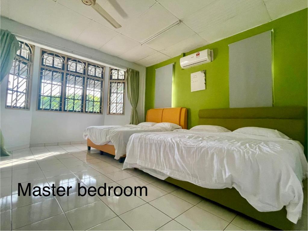 three beds in a room with green walls at LOW SEASON PROMOTION! 4B12B max 25 pax Party House in Ipoh