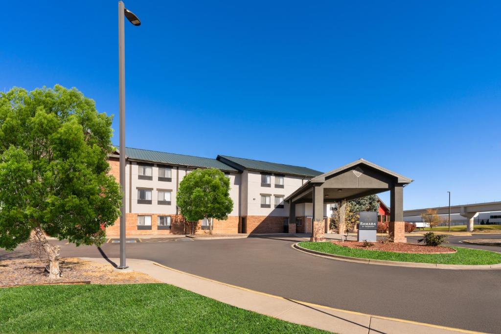 an apartment building with a pavilion in front of it at SYLO Hotel Denver Airport, a Ramada by Wyndham in Aurora