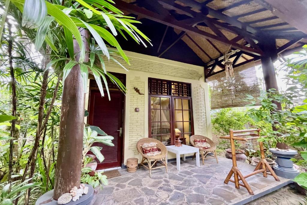 a porch of a house with a table and chairs at Raja's Bungalows in Senggigi