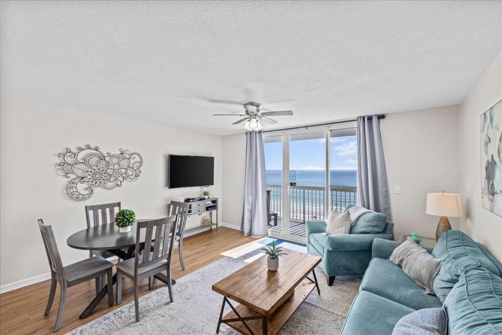 Una sala de estar con un sofá azul y una mesa. en Pelican Beach Resort 809, en Destin