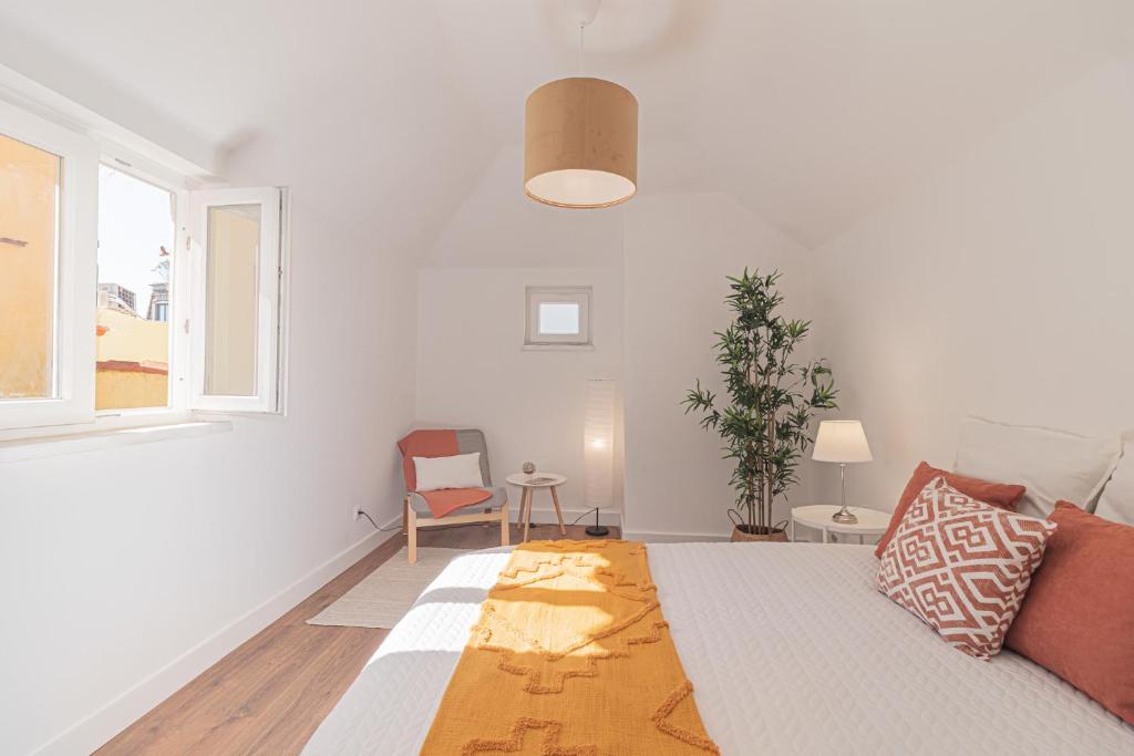 a white living room with a couch and a window at Stylish apartment in the heart of Lisbon in Lisbon