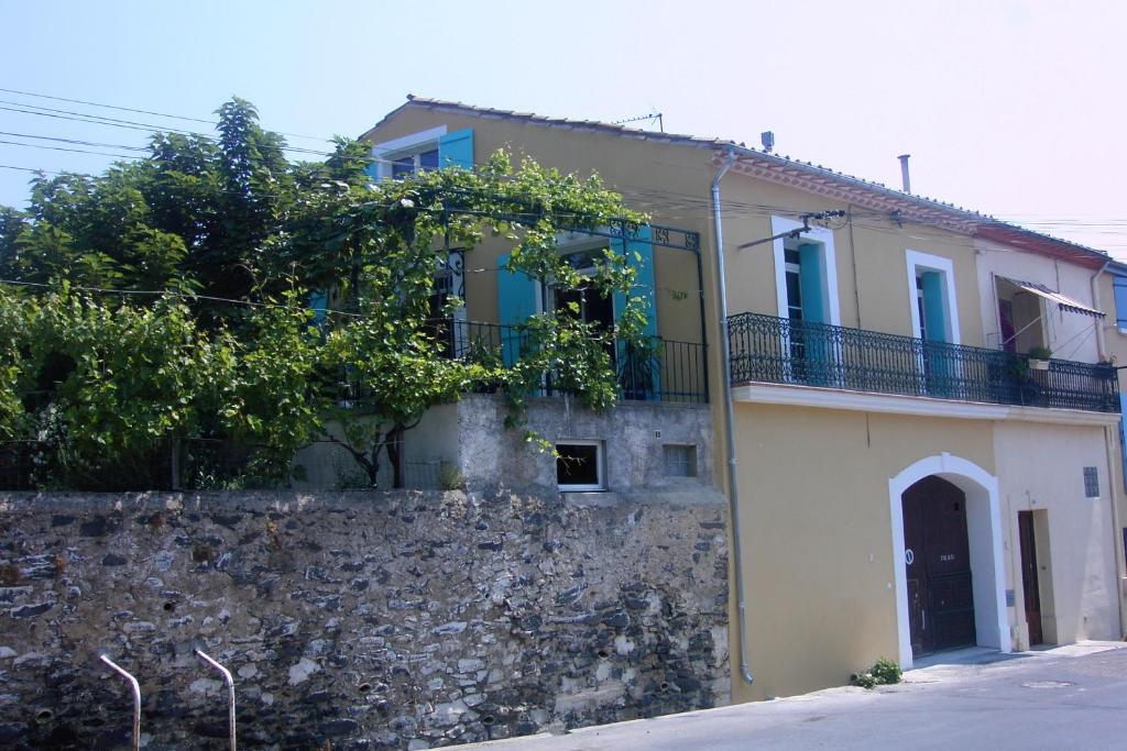 une maison avec un mur en pierre et une clôture dans l'établissement Holiday house in Valros, à Valros