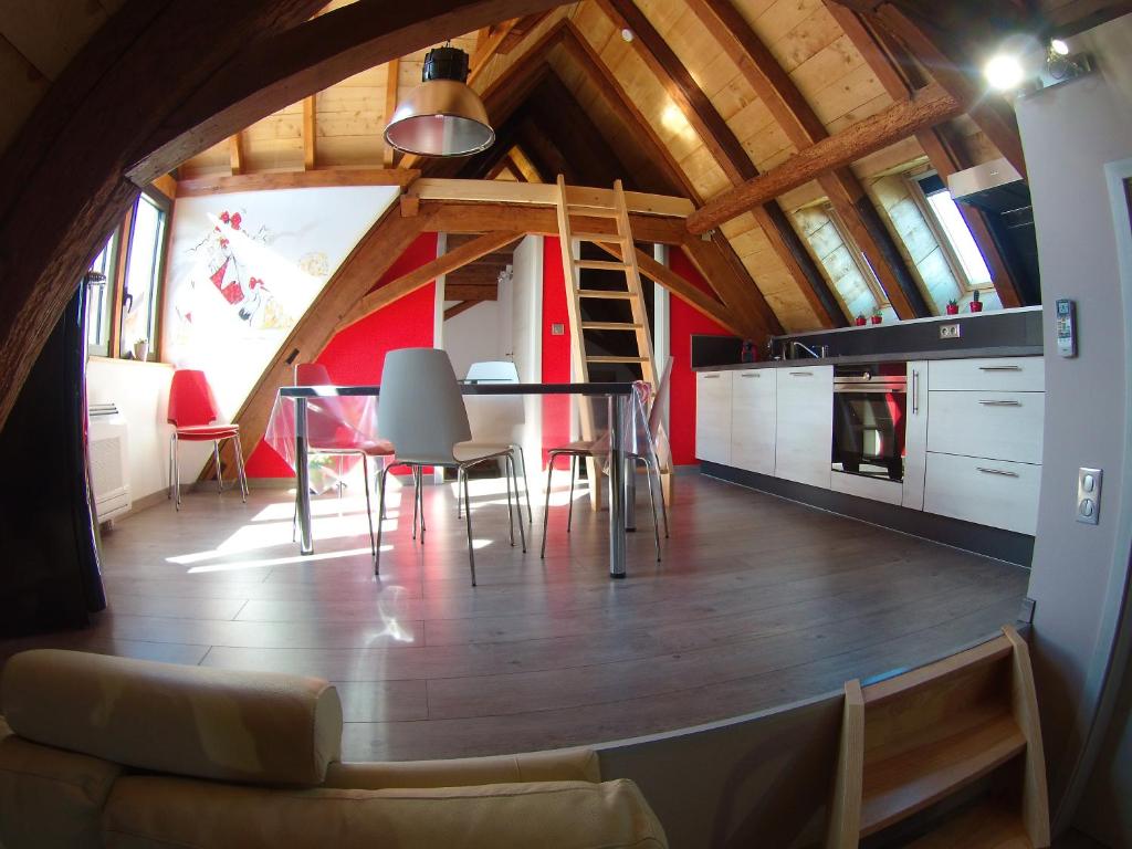 uma cozinha e sala de jantar com mesa e cadeiras em Gîte autonome, La grange a foin, piscine ! em Bergholtz