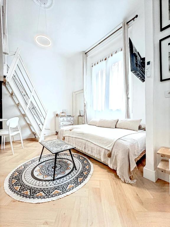 - une chambre blanche avec un lit et un tapis dans l'établissement Mini Duplex 50m du Vieux Port, à Cannes
