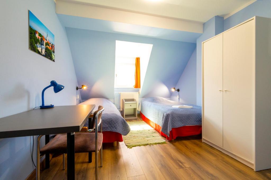 a bedroom with blue walls and a desk and a bed at 16eur - Old Town Munkenhof in Tallinn