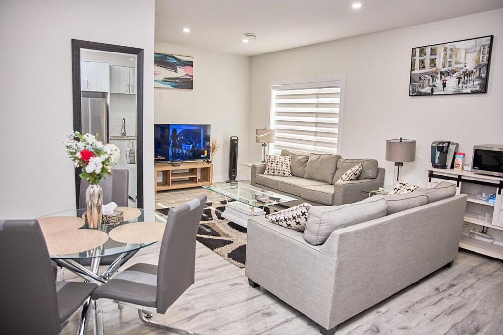 ein Wohnzimmer mit Couch und Tisch in der Unterkunft Brand-new three bedroom guest suite in the desirable neighbourhood in Prince George