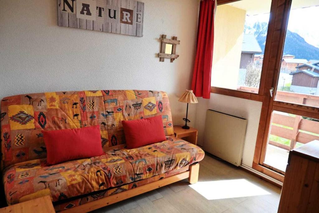 - un salon avec un canapé et des oreillers rouges dans l'établissement Résidence Michailles - Studio 4 personnes à Vallandry en centre station et proche des pistes MAE-2108, à Peisey-Nancroix