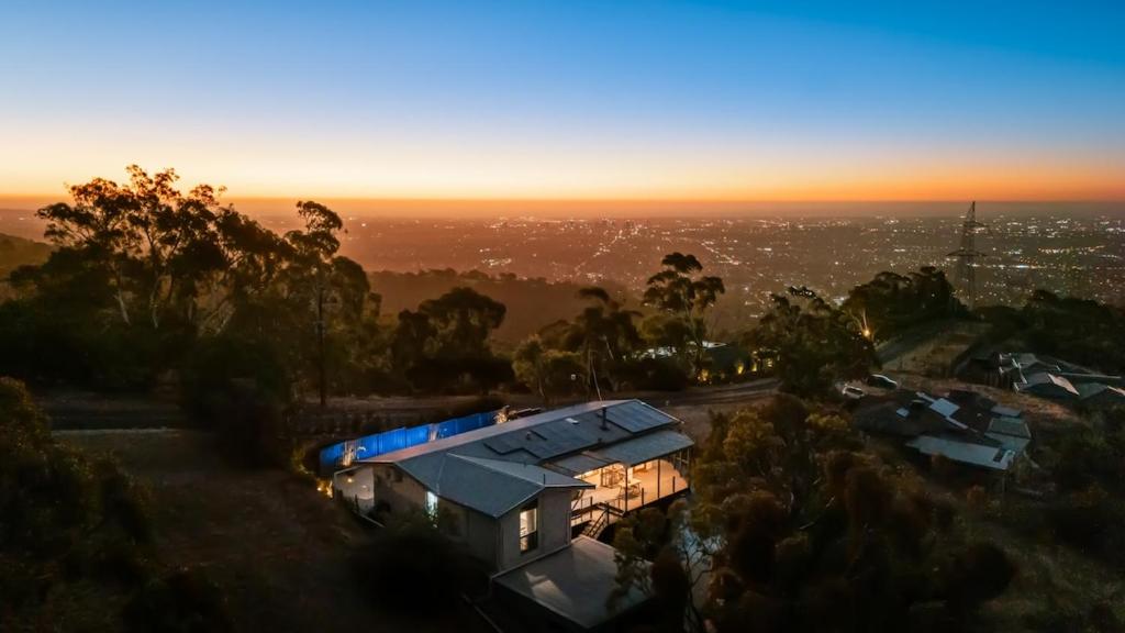 a house with a blue roof sitting on top of a hill at Teringie Retreat with Breathtaking Views in Norton Summit