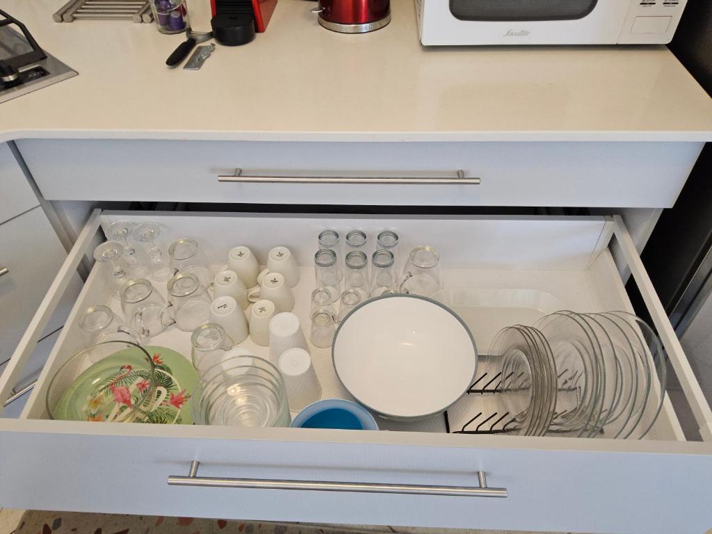 eine Schublade mit Geschirr und anderen Gegenständen in einem Kühlschrank in der Unterkunft shohamseaview in Eilat