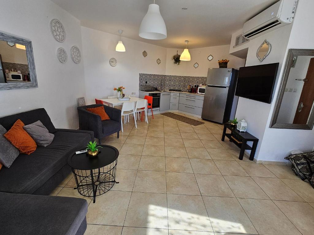 ein Wohnzimmer mit Couch und Küche in der Unterkunft shohamseaview in Eilat