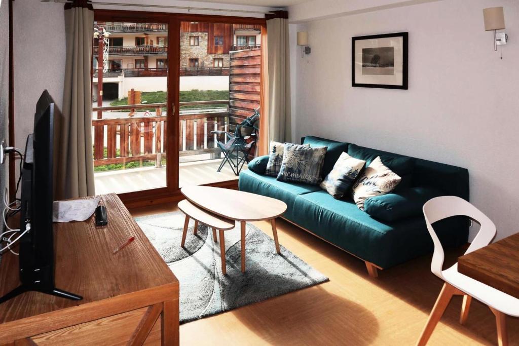 un salon avec un canapé vert et une table dans l'établissement Résidence Parc Des Airelles - APPARTEMENT PARC DES AIRELLES 111 MAE-0224, aux Orres