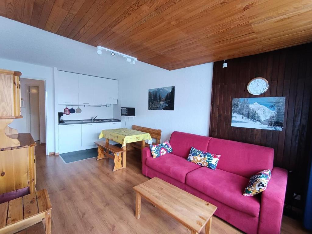 un salon avec un canapé rose et une table dans l'établissement Résidence Loubatiere - Appartement basic, proches pistes et commerces MAE-8874, à Montgenèvre