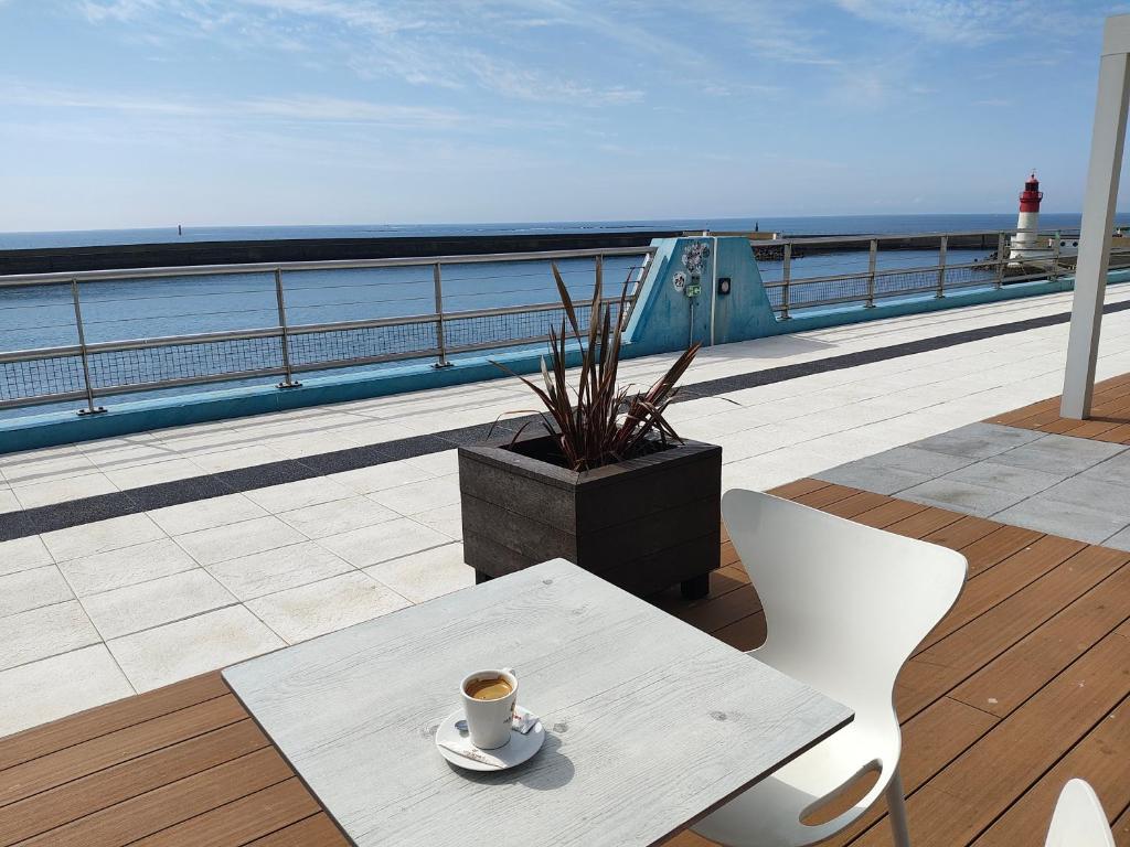 - une tasse de café assise sur une table sur un balcon dans l'établissement Maison entière Guilvinec, au Guilvinec