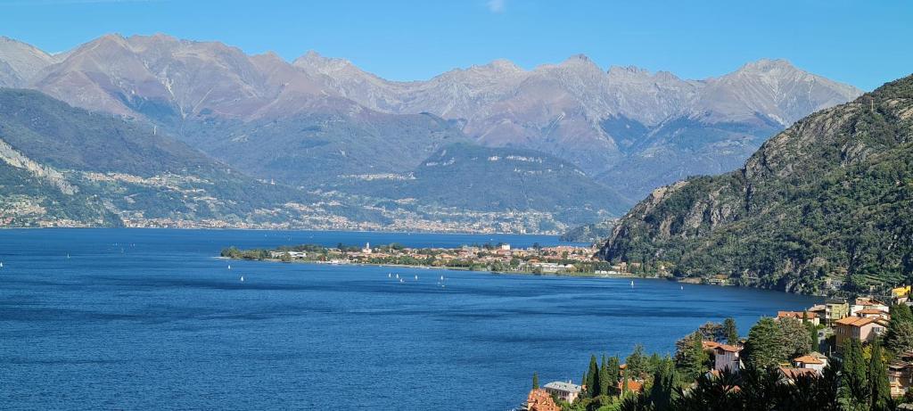 une grande étendue d'eau avec des montagnes en arrière-plan dans l'établissement Villa Sunset - Luxury property with pool & large private garden and parking, few steps from the beach, ideal for singles, couples and a family, à Dervio