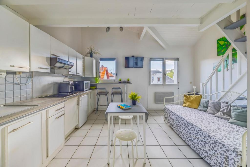 une cuisine et un salon avec un canapé et une table dans l'établissement The Cocon de Biarritz, à Cambo-les-Bains