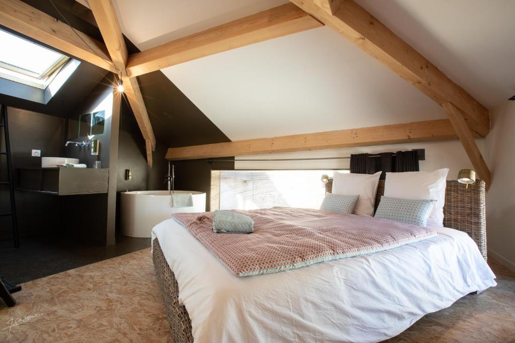 a bedroom with a large bed in a attic at La Métairie Du Clos Saint Louis, 4 chambres pour 8 personnes in Montréal