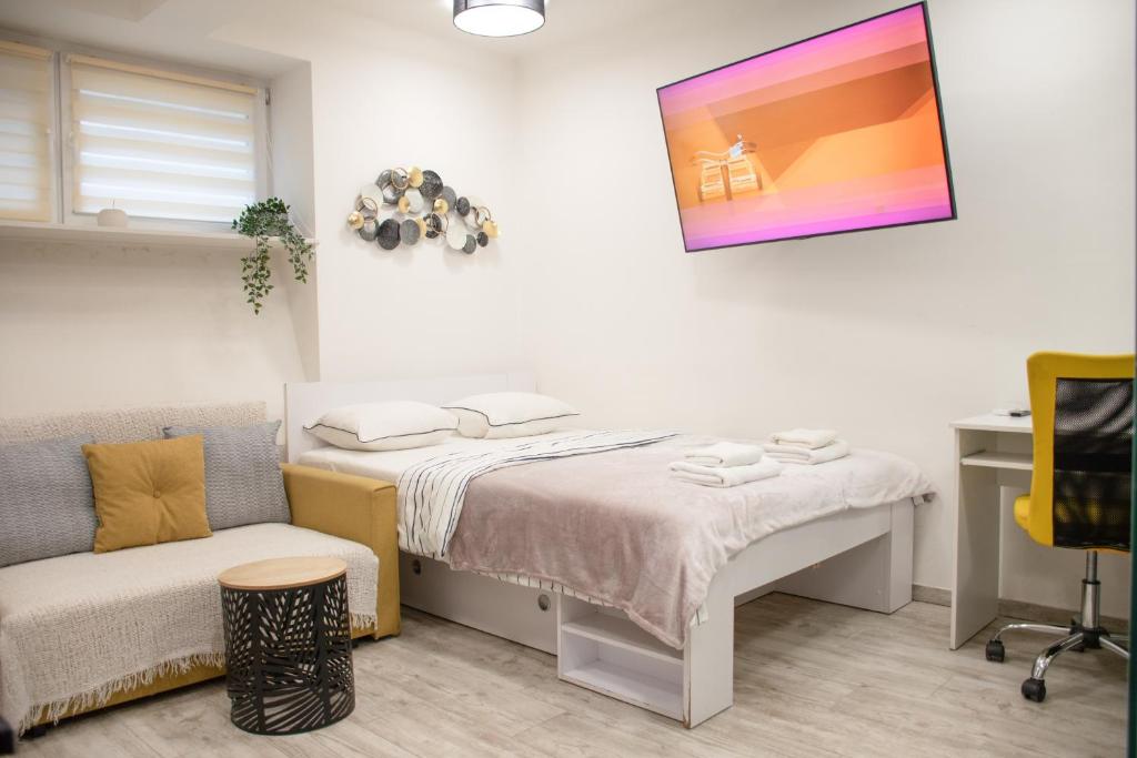 mała sypialnia z łóżkiem i kanapą w obiekcie Eight Lamps 'n Floor Heating w Zagrzebiu