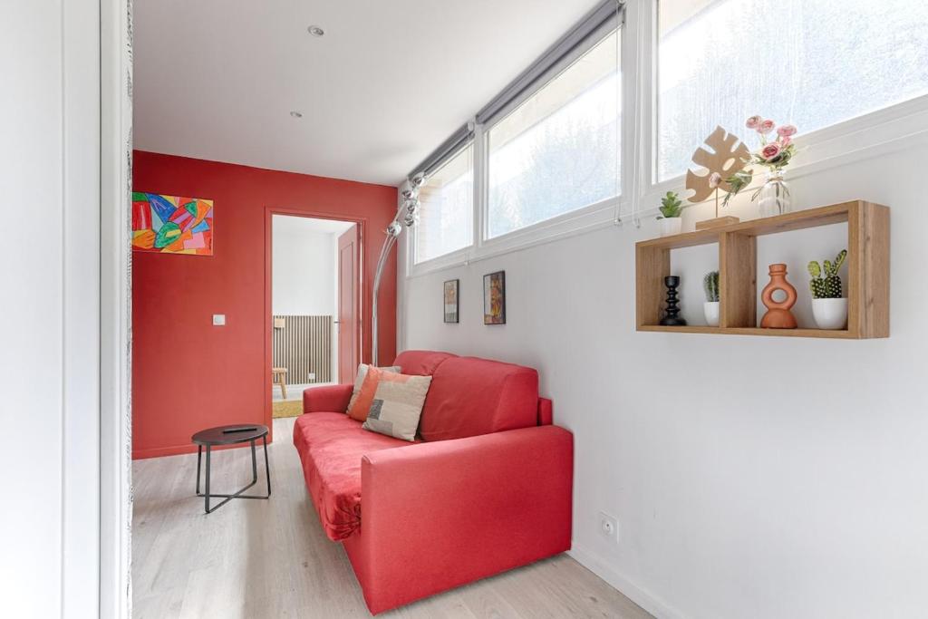 - un canapé rouge dans le salon aux murs rouges dans l'établissement Charming Gambetta Saint Fargeau I apartment, à Paris