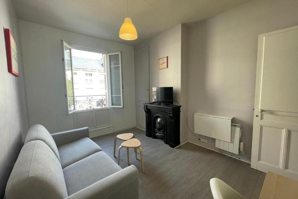 - un salon avec un canapé et une cuisinière dans l'établissement Le nid Havrais, au Havre