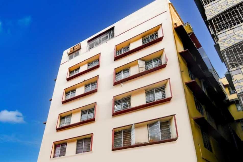 a tall white building with many windows at Hotel O Kalikapur Haltu in Kolkata