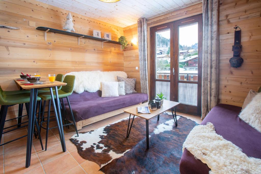 un salon avec un canapé violet et une table dans l'établissement Great value simple studio, à Morzine