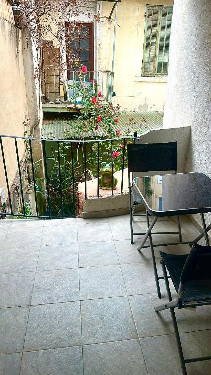 une terrasse avec une chaise, une table et une clôture dans l'établissement Flc - Charmant T3 neuf - Saint-charles 1,5km - clim et parking, à Marseille