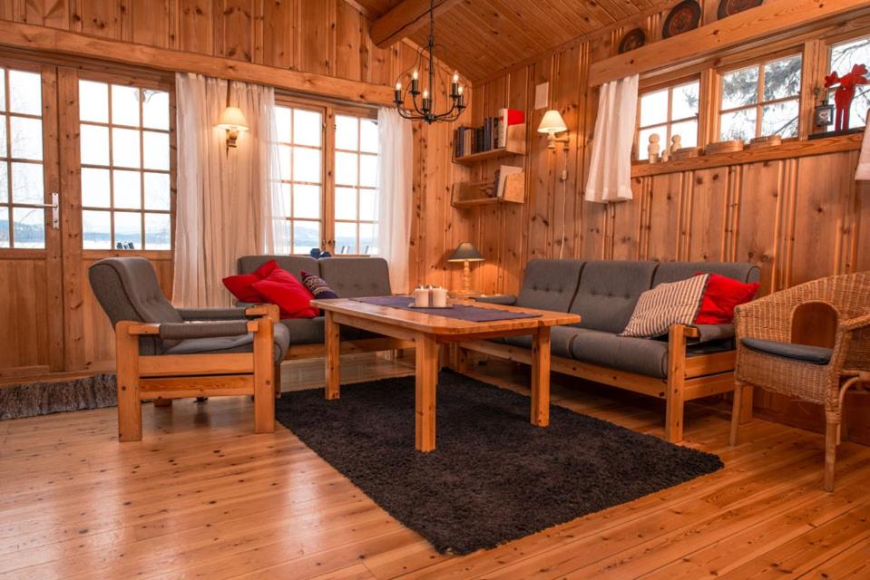 a living room with a couch and a table at Hagali by Norgesbooking - cabin by the lake Næra, close to Sjusjøen in Ringsaker