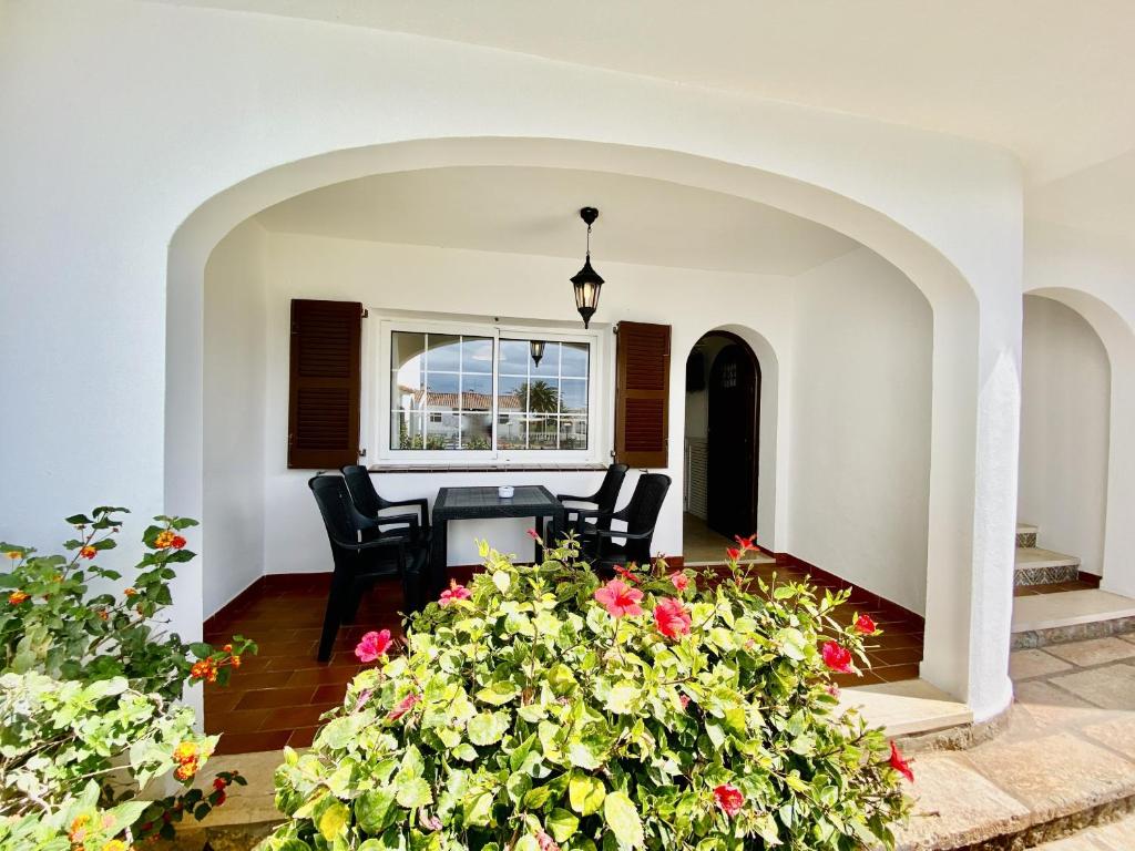 Una sala de estar con una mesa y algunas flores. en SAN JAIME 5 by SOM Menorca, en Son Bou