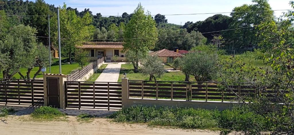 a house with a fence in front of a yard at Fish eye in Nikiti