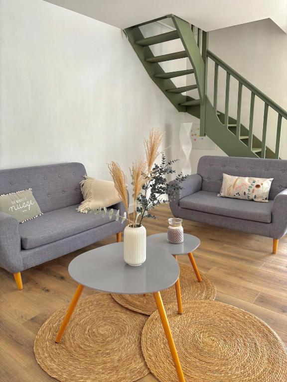 a living room with two couches and a table at Maison typique au cœur du centre ville in Saint-Gilles-Croix-de-Vie