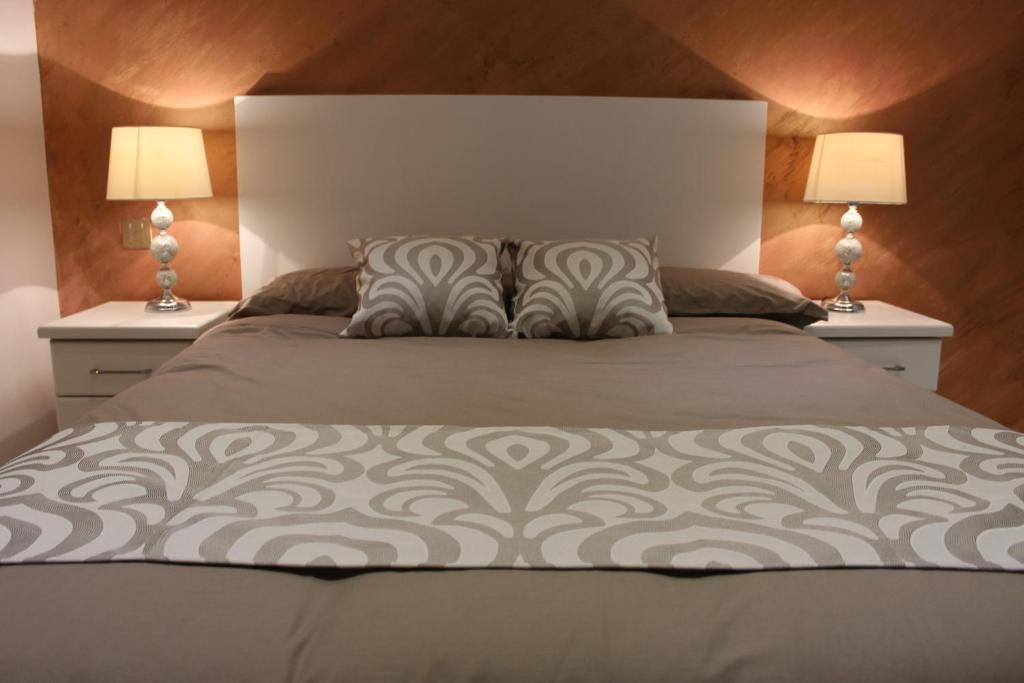 ein Schlafzimmer mit einem Bett mit zwei Nachttischen in der Unterkunft St. Elmo Apartments in Valletta