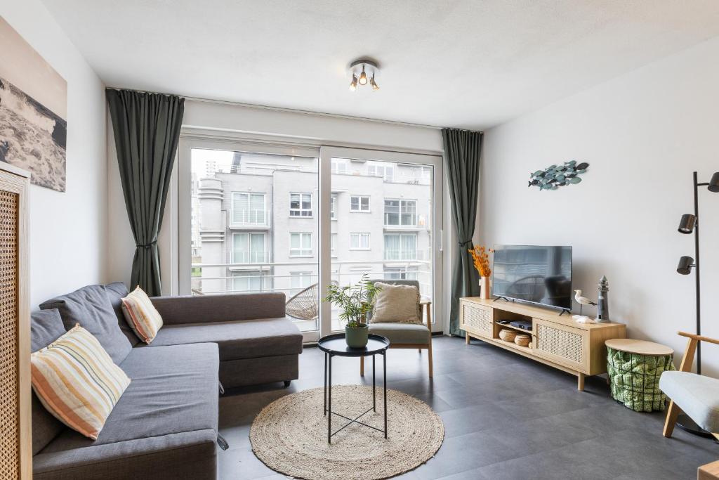 ein Wohnzimmer mit Sofa und Fernseher in der Unterkunft Century 2A 0201 in Wenduine