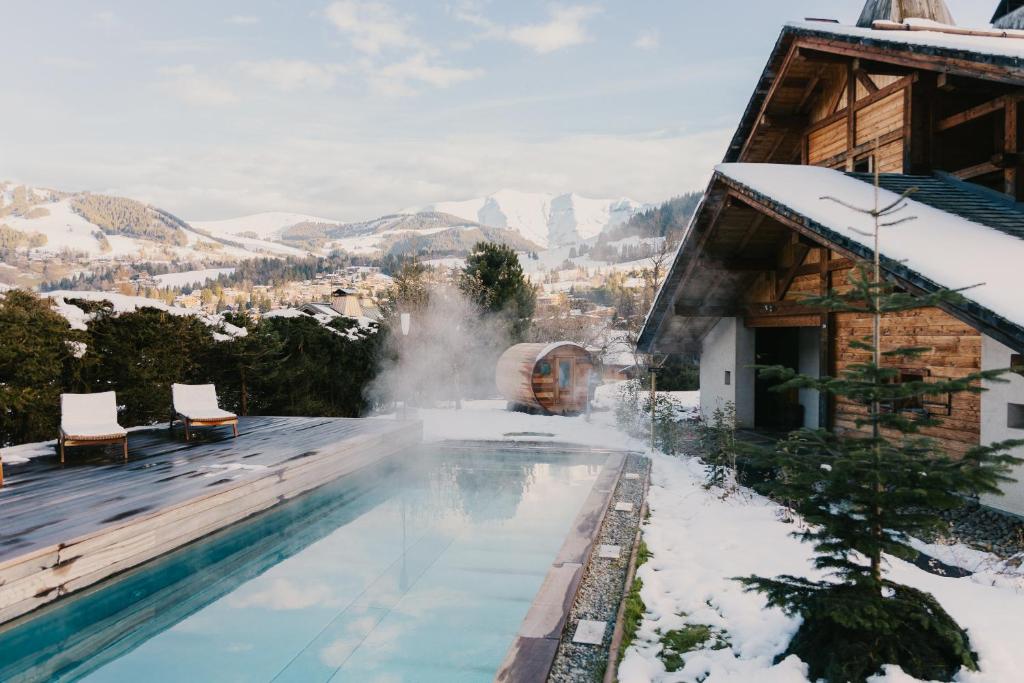 a house with a swimming pool in the snow at Chalets privés de L'Alpaga in Megève