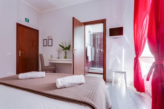 ローマにあるB&B Gallia's Roomsのベッドルーム1室(赤いカーテン付きの大型ベッド1台付)