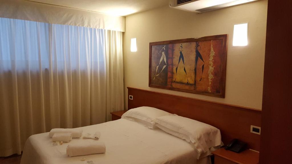a bedroom with a bed with two towels on it at Hotel Principe di Piemonte in Rimini