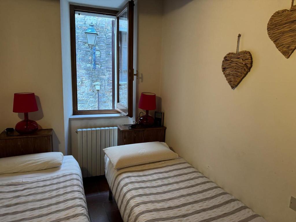 two beds in a room with a window at Country Home Marsciano in Marsciano