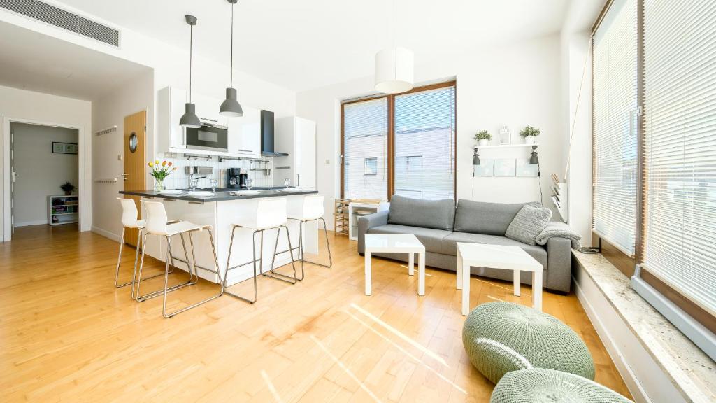 ミエンジズドロイェにあるGolden Tulip, Sun & Snowのソファとキッチンのあるリビングルーム