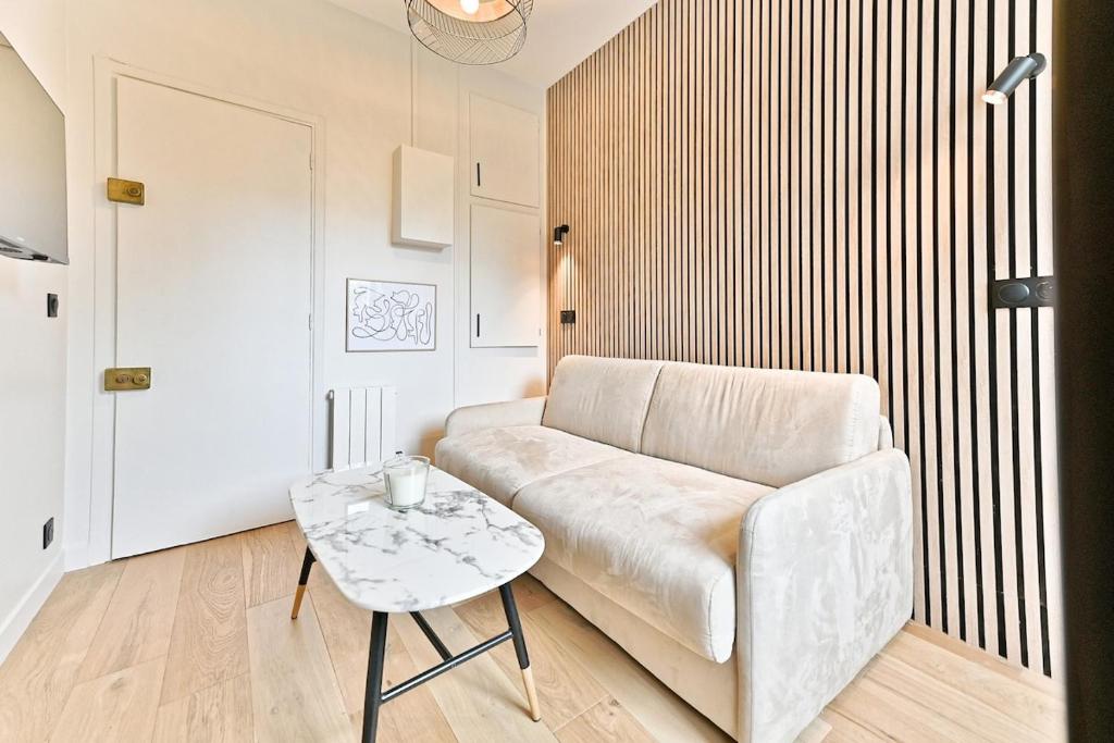 un salon avec un canapé et une table dans l'établissement Petit studio charmant près de Paris - III, à Neuilly-sur-Seine