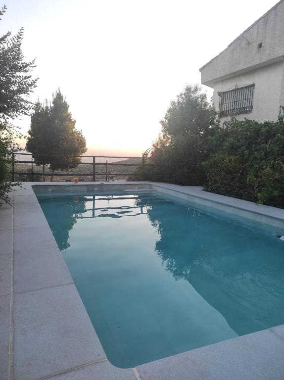 Una gran piscina azul frente a una casa en Casa los Huertecillos, en Nívar