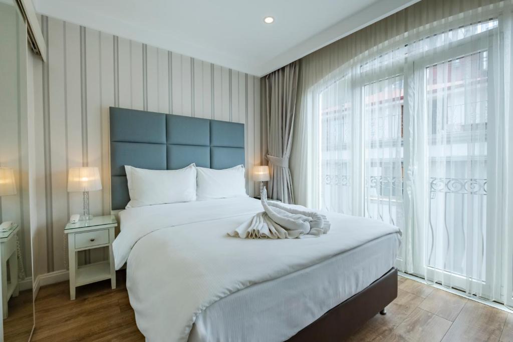 a bedroom with a large bed with a blue headboard at Ten Rooms Istanbul Hotel in Istanbul